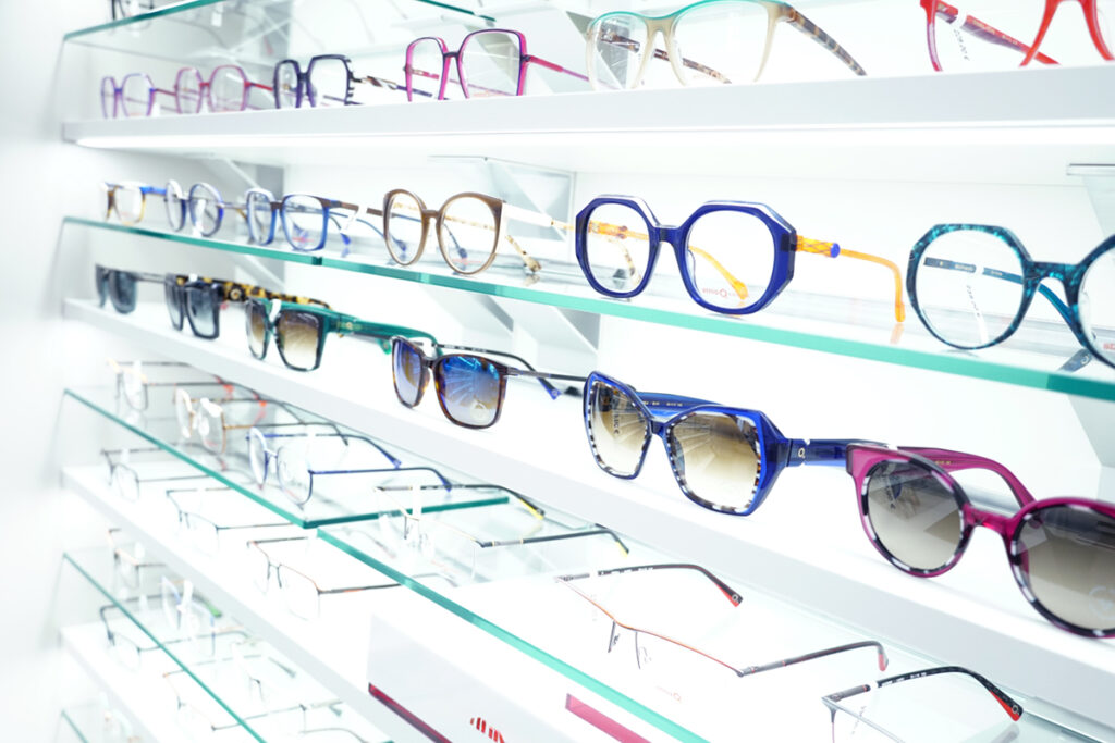 Farbenfrohe Brillen und Sonnenbrillen in Präsentationsregal